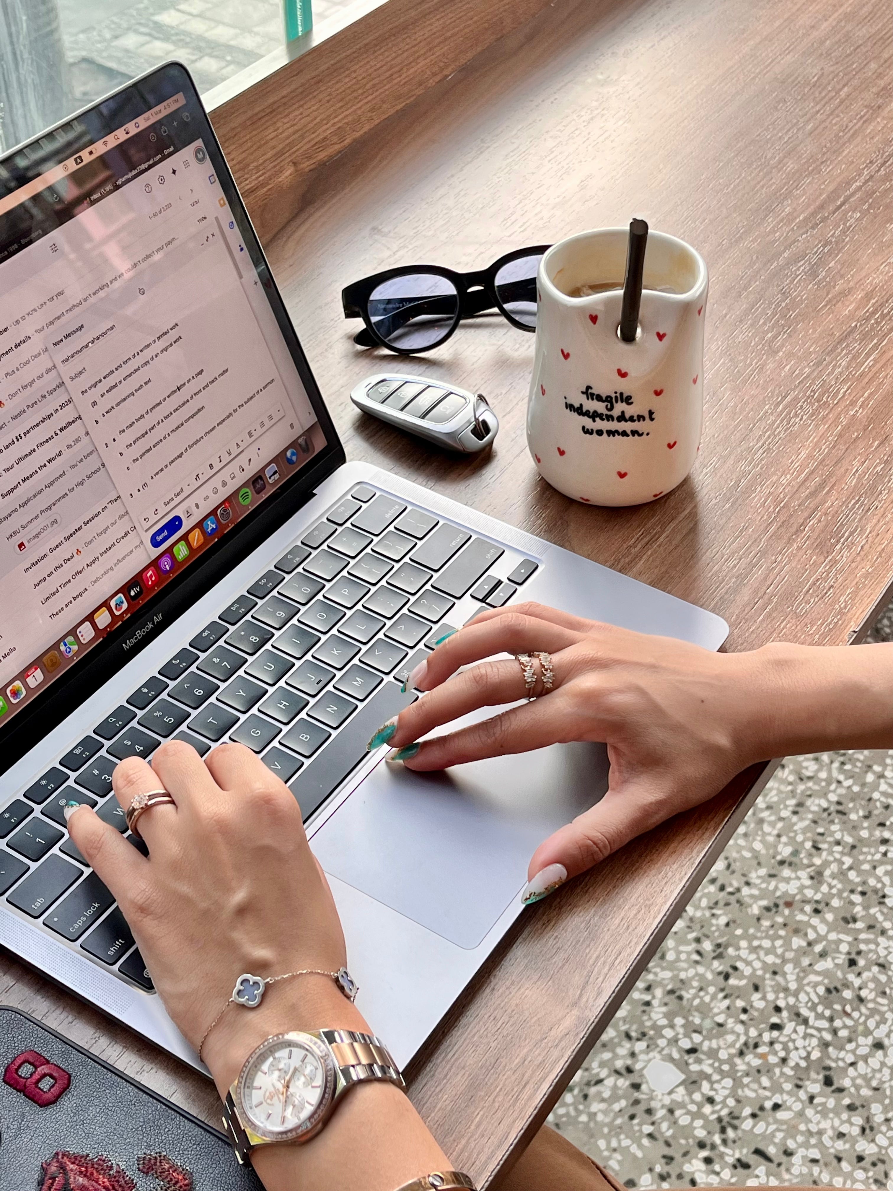 white tumbler with the text 'Fragile independent woman' printed on it, also holding a smartphone. handmade ceramic tumbler for iced coffee iced tea smoothies macha for girl boss entrepreneur 